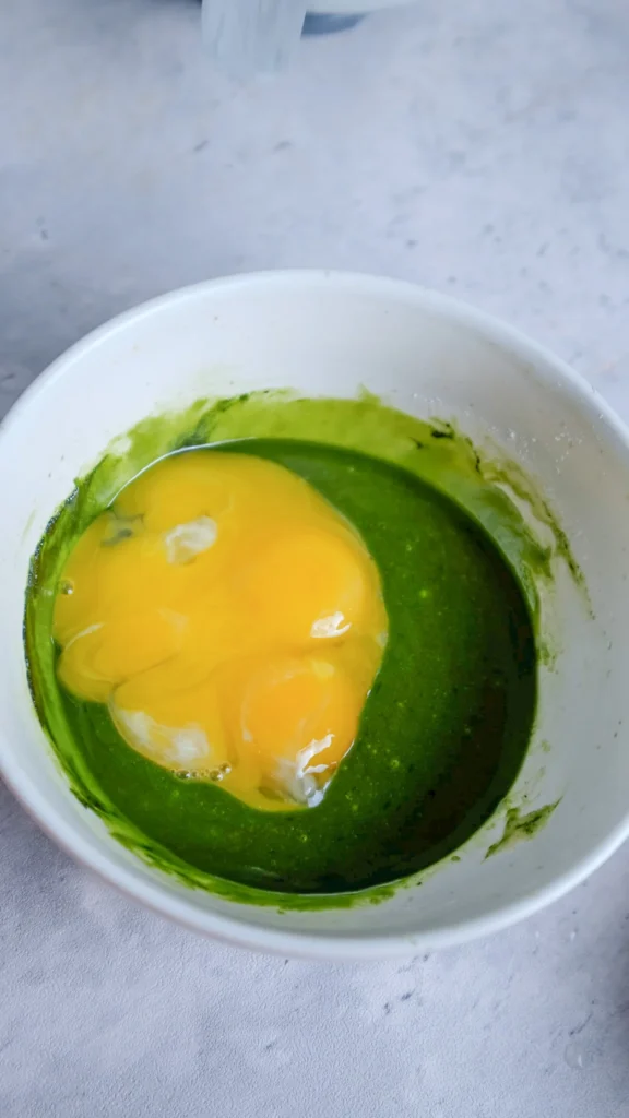 Matcha cake flour, match and oil in bowl all mixed together with egg yolks added 