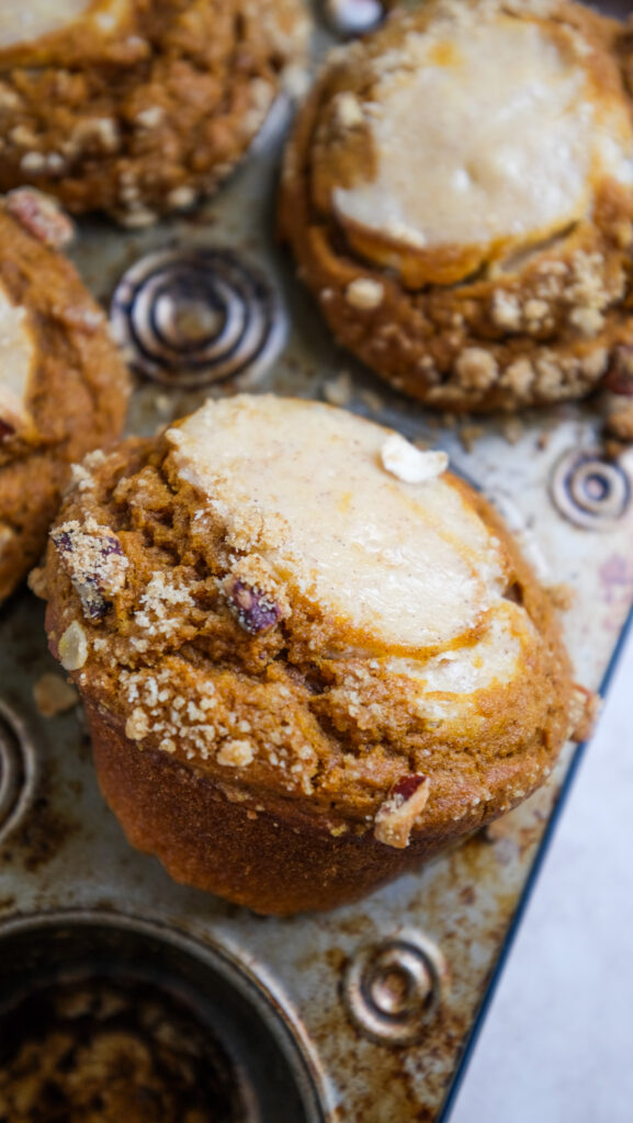 Pumpkin cream cheese muffins baked with one muffin at an angle 