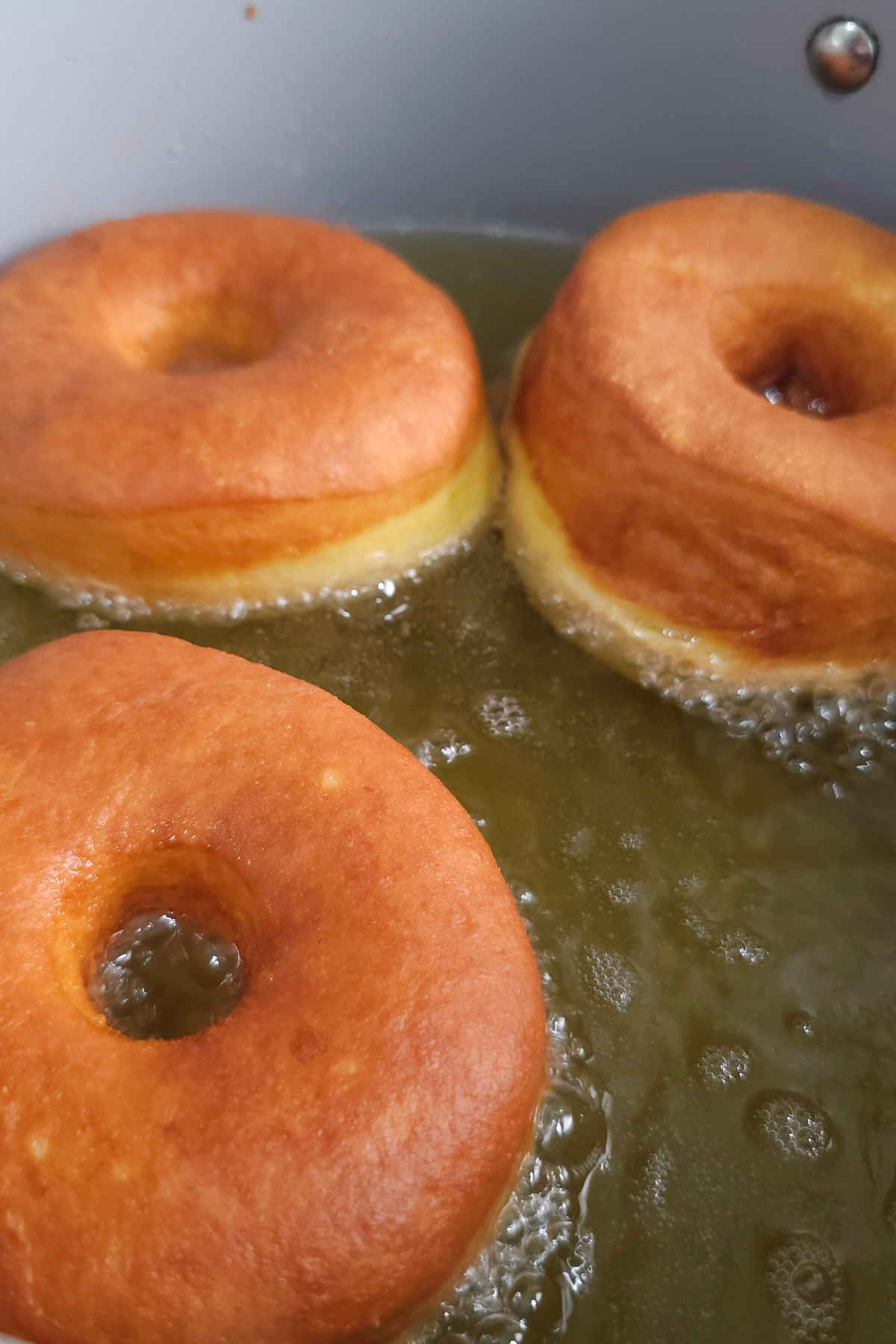 pumpkin donuts get flipped over to cook on other side