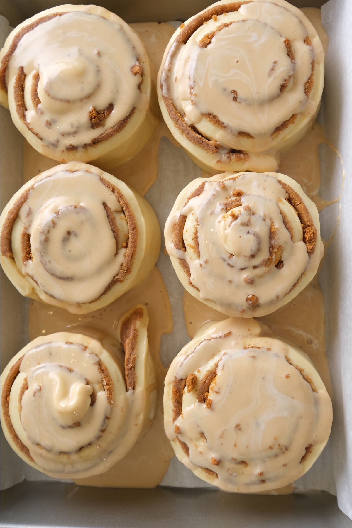 biscoff heavy cream is poured over biscoff cinnamon rolls