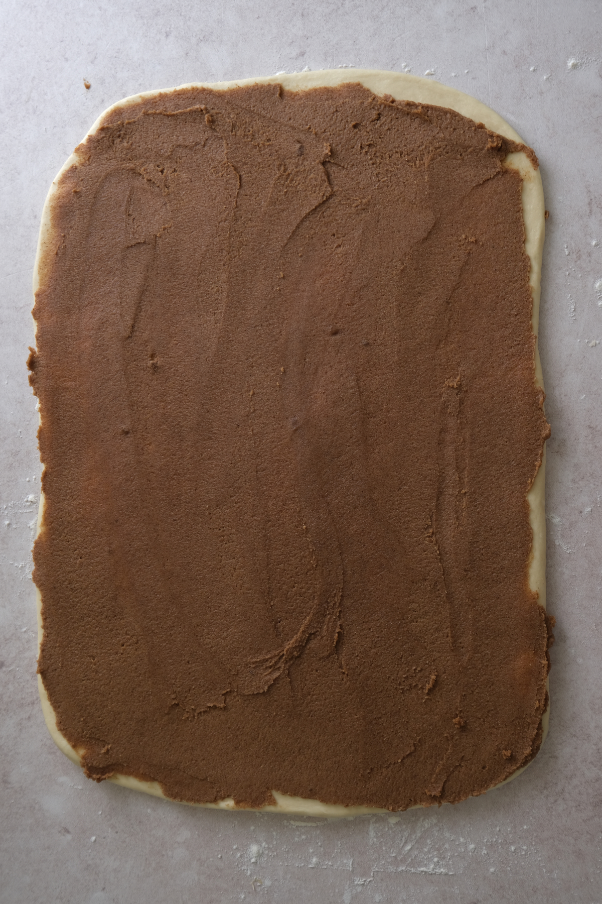 spiced brown sugar filling is spread on the dough